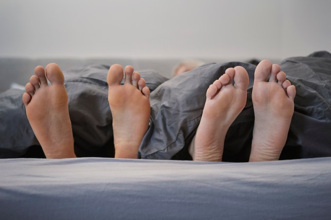 Feet of couple in bed